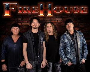 Four men pose in front of a brick wall under a glowing 'FireHouse' sign, wearing dark denim and black shirts, rock band vibe clearly shown.